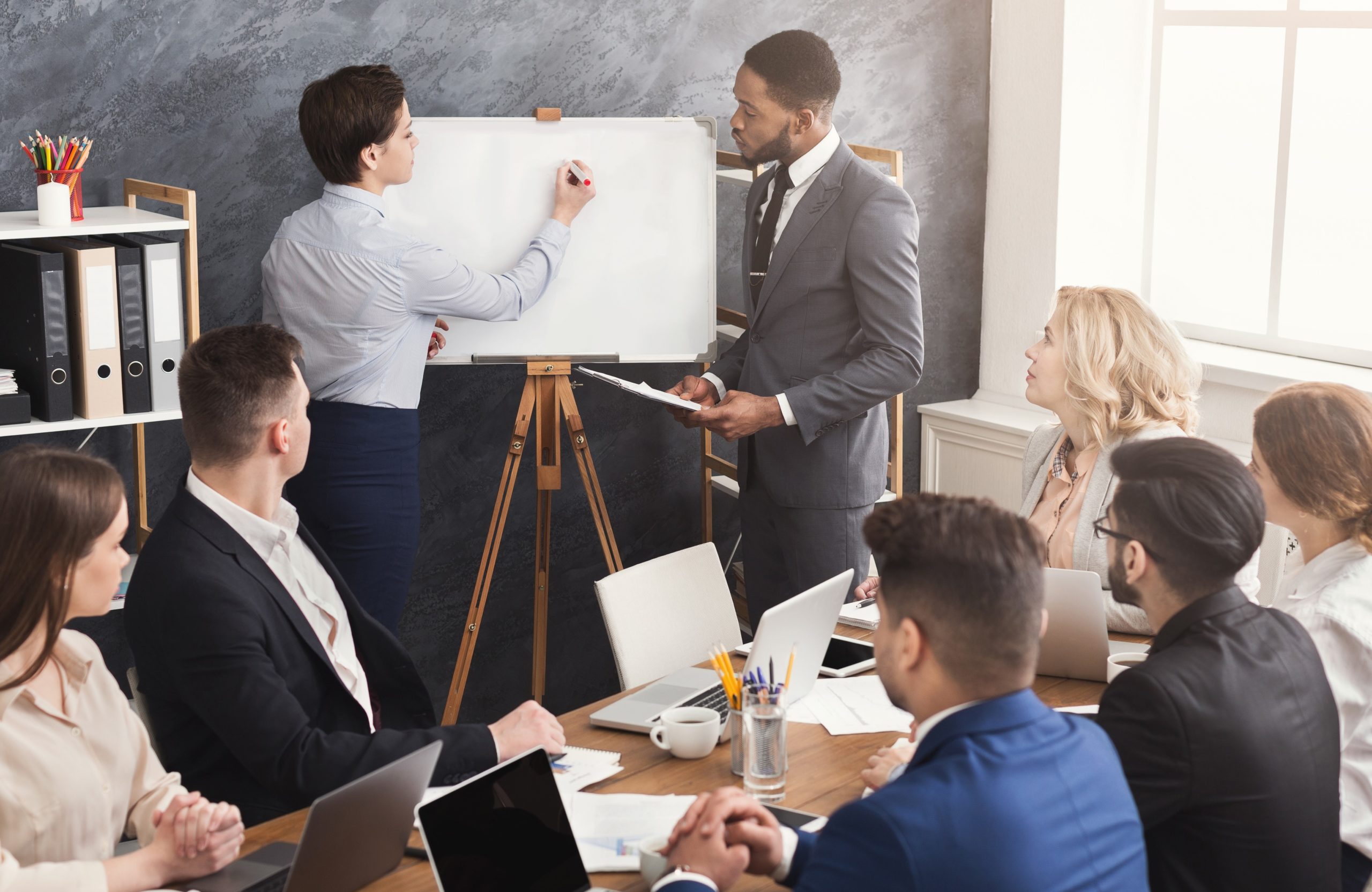 Woman and man giving presentation to colleagues in office